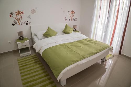 a bedroom with a bed with a green comforter at Apartments Malina in Vir