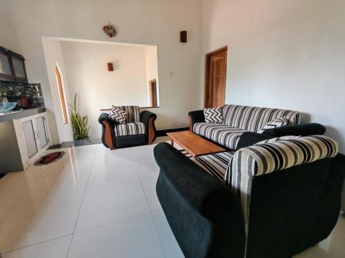 a living room with two couches and a table at Thaksilu Home in Mirissa