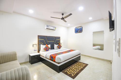 a bedroom with a king sized bed and a couch at FabHotel Tulip Sarover in New Delhi