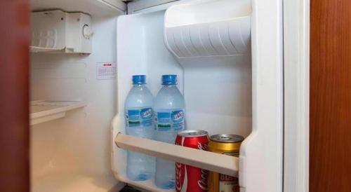 ハノイにあるCWD Hotelの水のボトルや缶が詰まった冷蔵庫