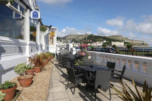 a balcony with tables and chairs and potted plants at Imperial Hotel in Llandudno