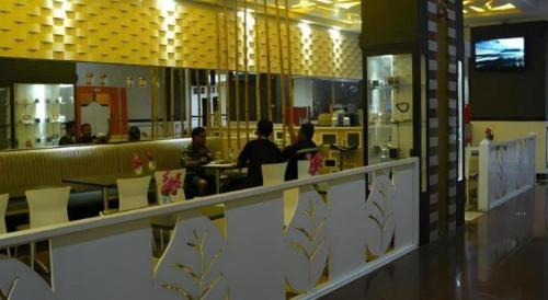 un restaurante con gente sentada en las mesas de una cafetería en V3 Hotel, en Surabaya