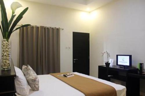 pokój hotelowy z łóżkiem i biurkiem z komputerem w obiekcie Nakula Stay Kuta w mieście Kuta
