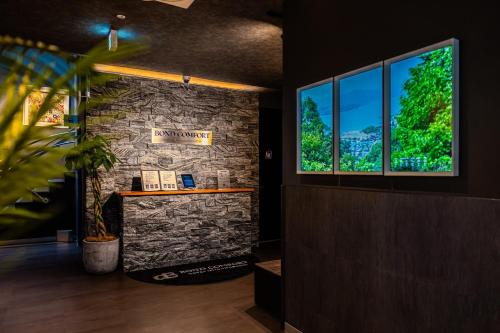 a room with a stone wall and a window at BOND COMFORT HOTEL MIYAJIMAGUCHI - Vacation STAY 79227v in Hatsukaichi
