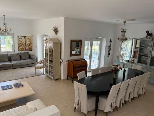 a dining room and living room with a table and chairs at Sleeps 12 Family Villa By The Sea W Jacuzzi & Pool in Jisr ez Zarqā