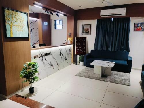 a waiting room at a hospital with a blue couch at Hotel Royal Park Rooms in Vapi