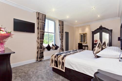 a bedroom with a large bed and a large window at Diamond Lodge Boutique Adults Only Guest House in Ambleside