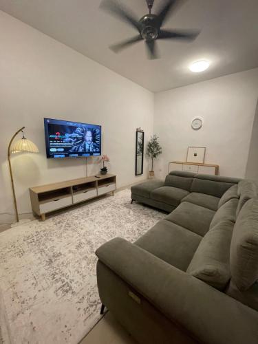 ein Wohnzimmer mit Couch und Flachbildfernseher in der Unterkunft Orked Homestay 2 Parit Buntar in Parit Buntar