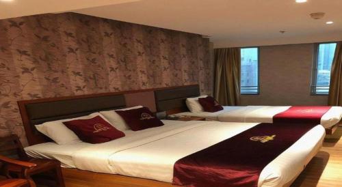 香港にあるMetro Winner Hotelの赤い枕が置かれたホテルの部屋にはベッドが2つある