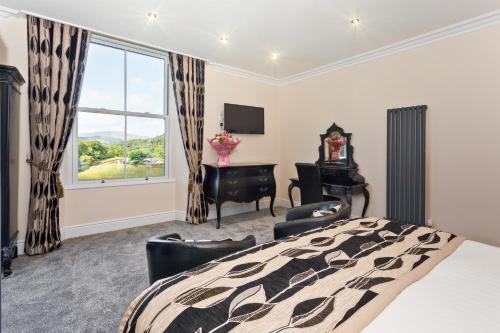 a bedroom with a bed and a desk and a window at Diamond Lodge Boutique Adults Only Guest House in Ambleside