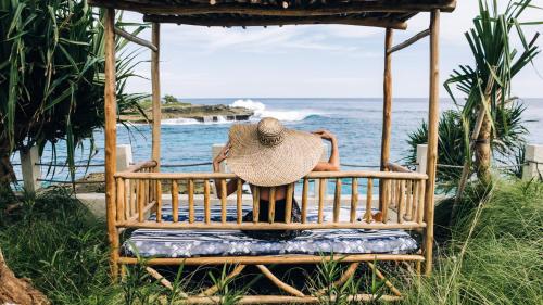 a person sitting in a gazebo with a hat at Naluna Lembongan in Nusa Lembongan