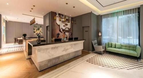 ein großes Wohnzimmer mit einer grünen Couch und einer Theke in der Unterkunft Magnotel Fuzhou Wuyi Road Sanfangqixiang in Fuzhou