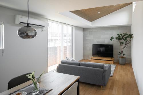 a living room with a couch and a tv at 暁の宿 in Koka