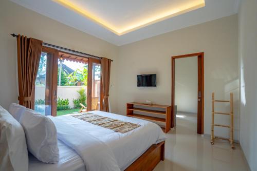 a bedroom with a large bed and a window at Gusti family guest house in Tegalalang