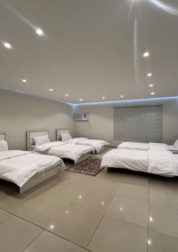 a row of beds in a room with a wall at شقق نرمادا المفروشة فرع قباء in Medina