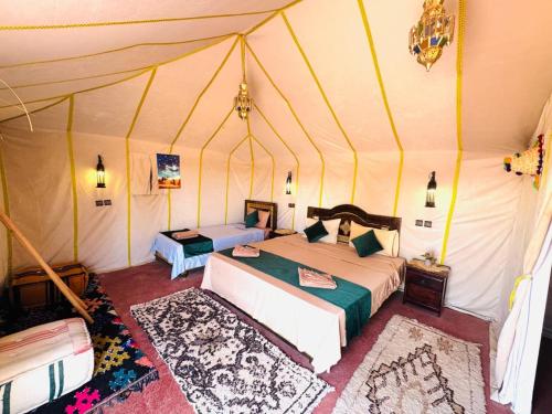 a bedroom with two beds in a tent at Sania Luxury Camp in Merzouga