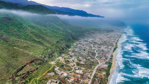 an aerial view of the ocean and a city at محمية حوف 