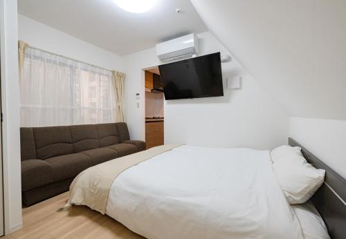 a bedroom with a bed and a couch at Hotel the World Omori in Tokyo