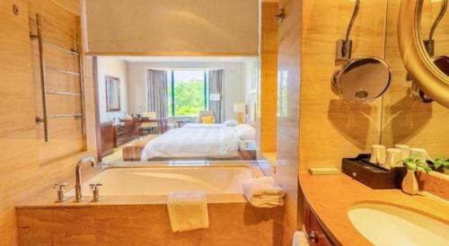 泉州市にあるQuanzhou Guest House Hotelのバスルーム(バスタブ付)、ベッド1台が備わります。