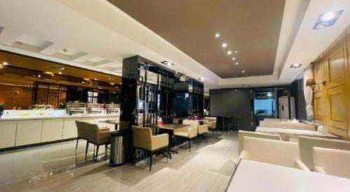 Un restaurante con mesas y sillas y un bar. en Jinjiang Inn Tai'an Taishan Railway Station, en Tai'an