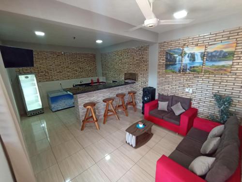 ein Wohnzimmer mit einem roten Sofa und einer Bar in der Unterkunft Casa Cristal in Barrio San Isidro (2)