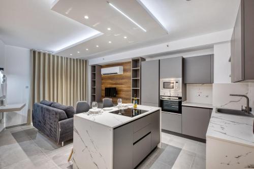 Una cocina y una sala de estar con un sofá y una mesa. en Offshore Suites Apartment in St Julians Centre, en San Julián