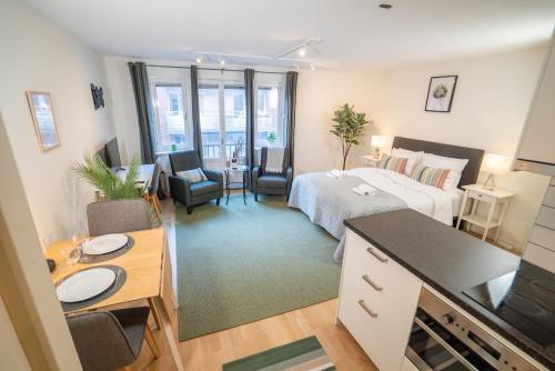 a bedroom with a bed and a desk and a room at Linné Studio, Green Comfort Steps Away From Haga in Gothenburg