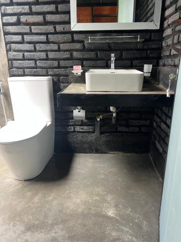 a bathroom with a toilet and a sink at Pepper Trails Riverstone in Polwattekanda