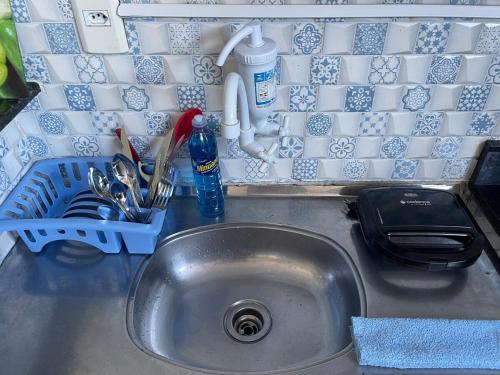un évier de cuisine avec un égouttoir à vaisselle à côté dans l'établissement Studio-style apartment in a family environment, à Salvador