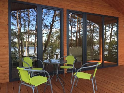 a screened porch with a table and chairs on a deck at Ośrodek Delfin in Ślesin