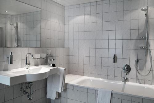 a bathroom with a sink and a bath tub at Hotel Restaurant Witte in Ahlen