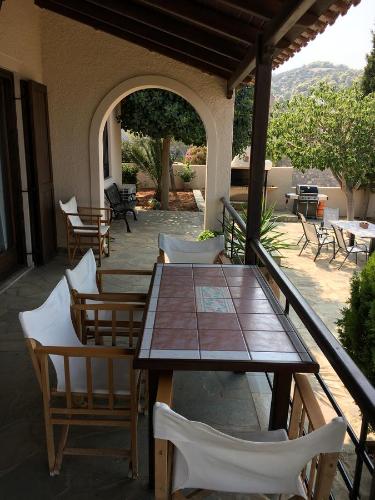a patio with a wooden table and chairs on a porch at Alexander Villa Pefkali in Pefkali