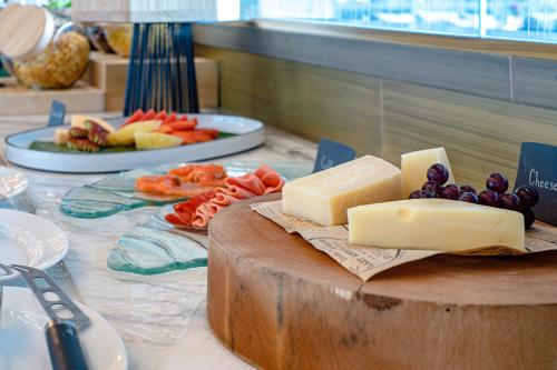 a table with cheese and grapes and a plate of food at V Villas Phuket - MGallery Collection in Panwa Beach