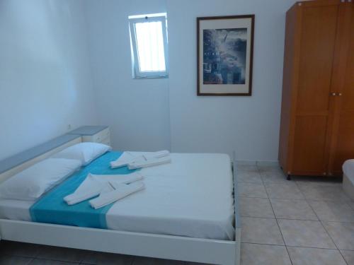 a bedroom with a bed with towels on it at Blue Nest Hotel in Tigaki