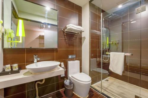 a bathroom with a sink and a toilet and a shower at IU Hotel Taiyuan Changfeng West Street The Mixc in Taiyuan