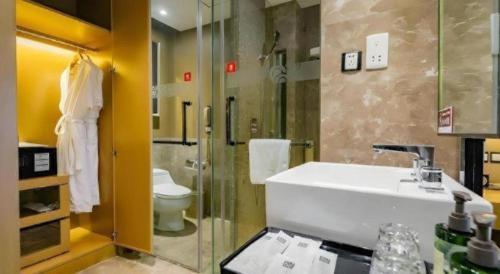 Un baño con lavabo, ducha e inodoro. en Ramada by Wyndham Xi'an Bell Tower, en Xi'an