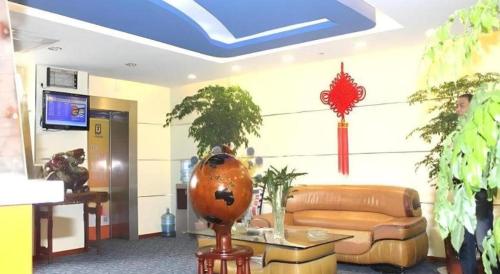 a lobby with a couch and plants in a room at 7 Days Inn Changzhou North Station in Changzhou