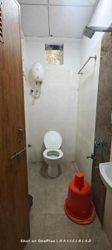 ein kleines Badezimmer mit Toilette und Waschbecken in der Unterkunft Hotel Comfort Vesu in Surat