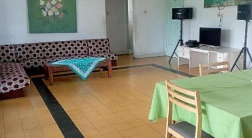 ein Wohnzimmer mit einer Couch und einem Tisch und Stühlen in der Unterkunft SURGA DIRGA RESORT in Puncak