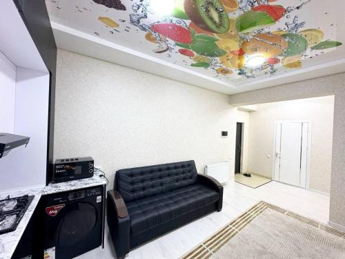 a living room with a couch and a painting on the ceiling at Comfortable Apartments in Tashkent