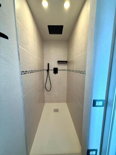 a bathroom with a shower with white tiles at La maison des Huskys in Sasso di Bordighera