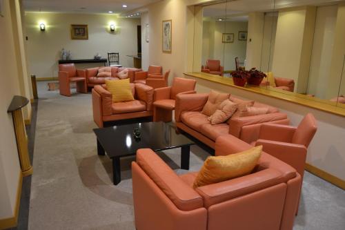 a waiting room with orange leather couches and chairs at Hotel Excelsior in Lanciano