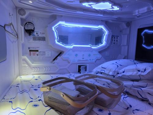 a room with a bed with a blue light at Hotel Galaxy Pod 本川越店 in Kawagoe