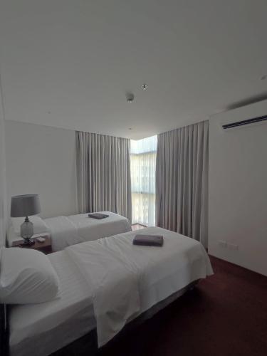 a hotel room with two beds and a window at Tambuli Seaside Resort 16G - Lapu Lapu in Maribago
