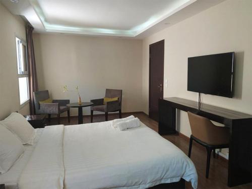 una habitación de hotel con cama y televisor de pantalla plana en Tsiriry Guest House, en Antananarivo