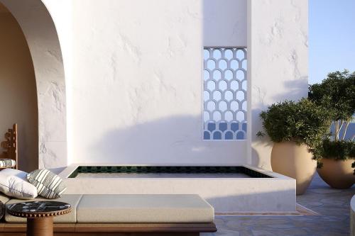 a white wall with a bench and some plants at One&Only Palmilla in San José del Cabo