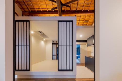an open door into a kitchen with black bars at Miharaya in Onomichi
