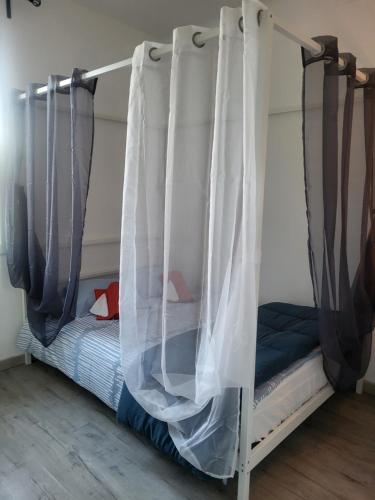 1 cama con dosel en un dormitorio en Maison BRIALI avec Jacuzzi espace détente, en Aubignan