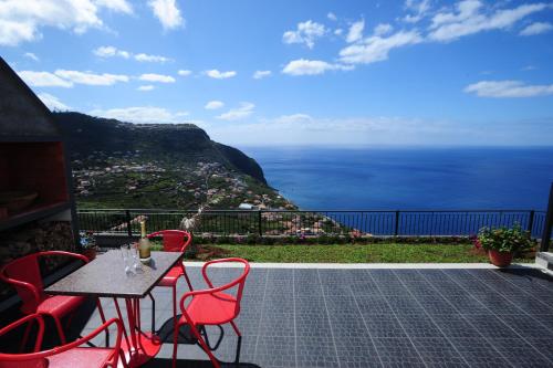 a table and chairs with a view of the ocean at Casa Horizonte in Arco da Calheta