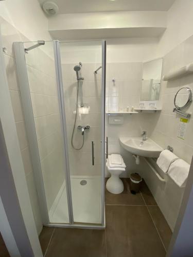 Un baño con ducha, inodoro y lavabo. en Hotel de Montaulbain, en Verdún